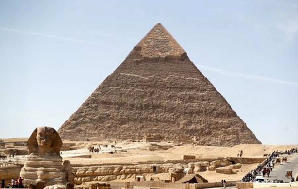 FILE PHOTO: Visitors are seen next to the Sphinx and the Great Pyramid at the Giza Plateau, on the outskirts of Cairo, Egypt, November 1, 2021. REUTERS/Mohamed Abd El Ghany/File Photo
