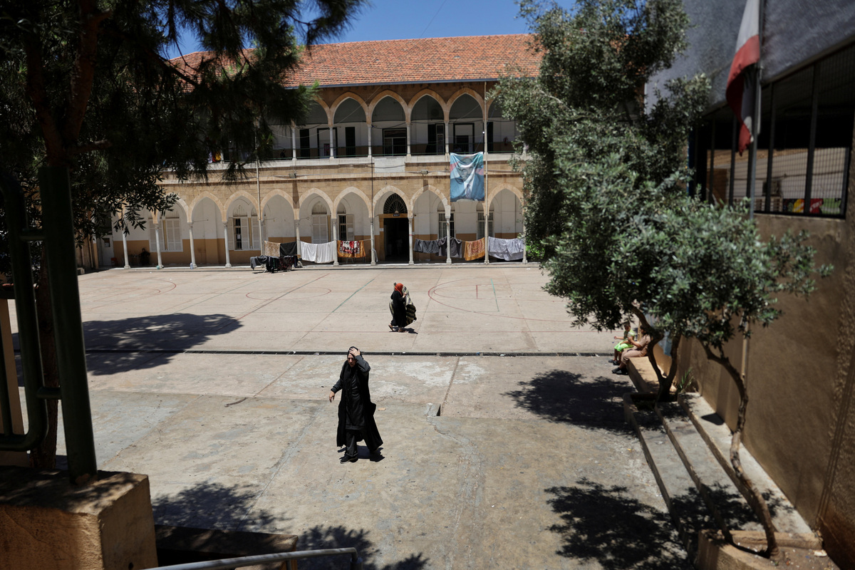 Women walk at a school that has been turned into a shelter for displaced families, following a deal between the United States and Iran, in Beirut, Lebanon, June 16, 2026. REUTERS/Khalil Ashawi