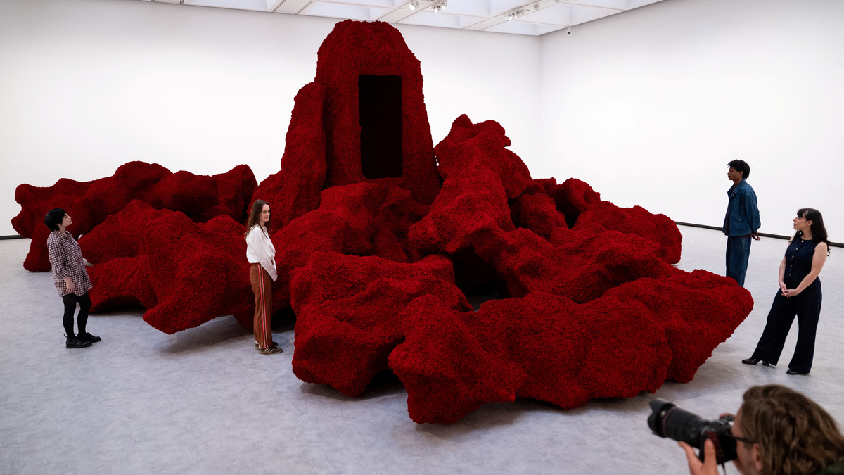 Gallery assistants pose for a photographs next to Anish Kapoor's installation 'Ha Makom' (2022) during the press view for 'Anish Kapoor' at the Hayward Gallery, in London, Britain, June 15, 2026. REUTERS/Chris J. Ratcliffe