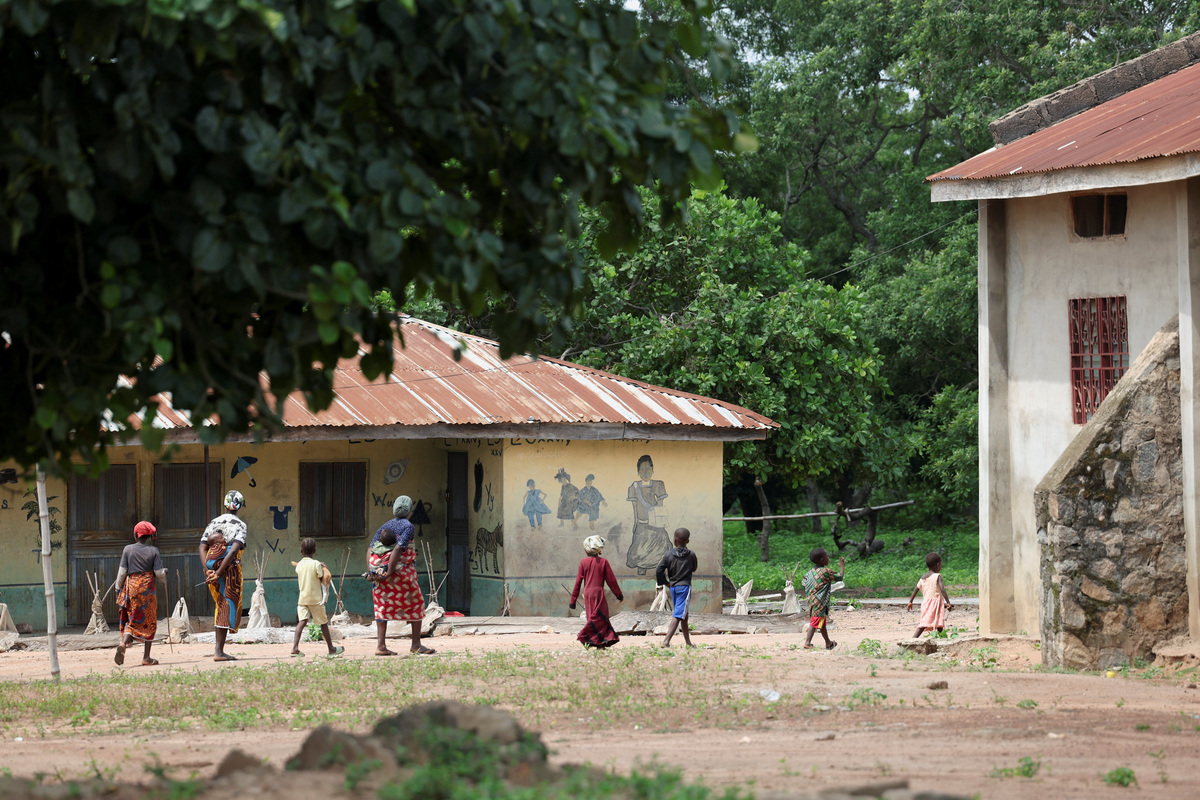 Women and children from the Yawota community walk past Baptist Nursery and Primary School, in Oyo State, Nigeria, June 2, 2026, where gunmen abducted dozens of students and teachers. REUTERS/Sodiq Adelakun