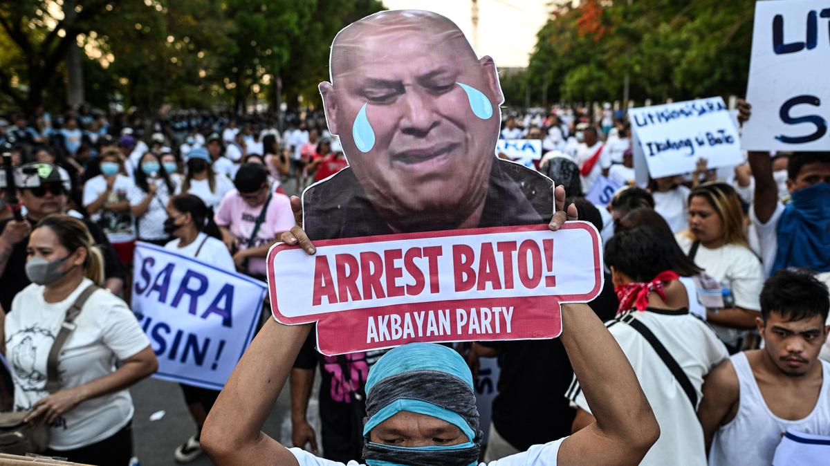 An activist displays a sign with a slogan calling for the arrest of Philippine Senator Ronald "Bato" dela Rosa's, during a protest outside the Philippine Senate, which holds dela Rosa, the chief enforcer of former president Rodrigo Duterte's drug war, in protective custody amid an International Criminal Court warrant, in Pasay City, Metro Manila, Philippines, May 13, 2026. REUTERS/Noel Celis