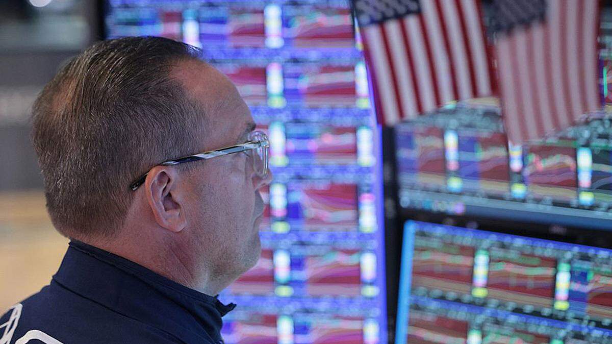 Traders work on the floor of the New York Stock Exchange in New York City on Monday. The S&P 500 and Nasdaq hit record closing highs on Tuesday, as AI-fueled optimism offset anxiety over Middle East peace talks.