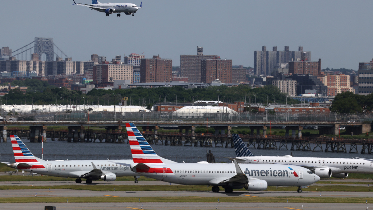 Planes cue on the runway for takeoff as another lands at New York's LaGuardia airport, where closure of one of the runways due to a sinkhole on Wednesday is expected to continue until early Saturday, snarling flights for the busy Memorial Day travel period in New York City, U.S., May 22, 2026. REUTERS/Shannon Stapleton