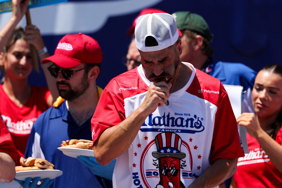 James Webb from Sydney, Australia, participates in the 2026 Nathan's Famous International Hot Dog Eating Contest, at Coney Island, Brooklyn in New York City, U.S., July 4, 2026. REUTERS/Jordan Tovin