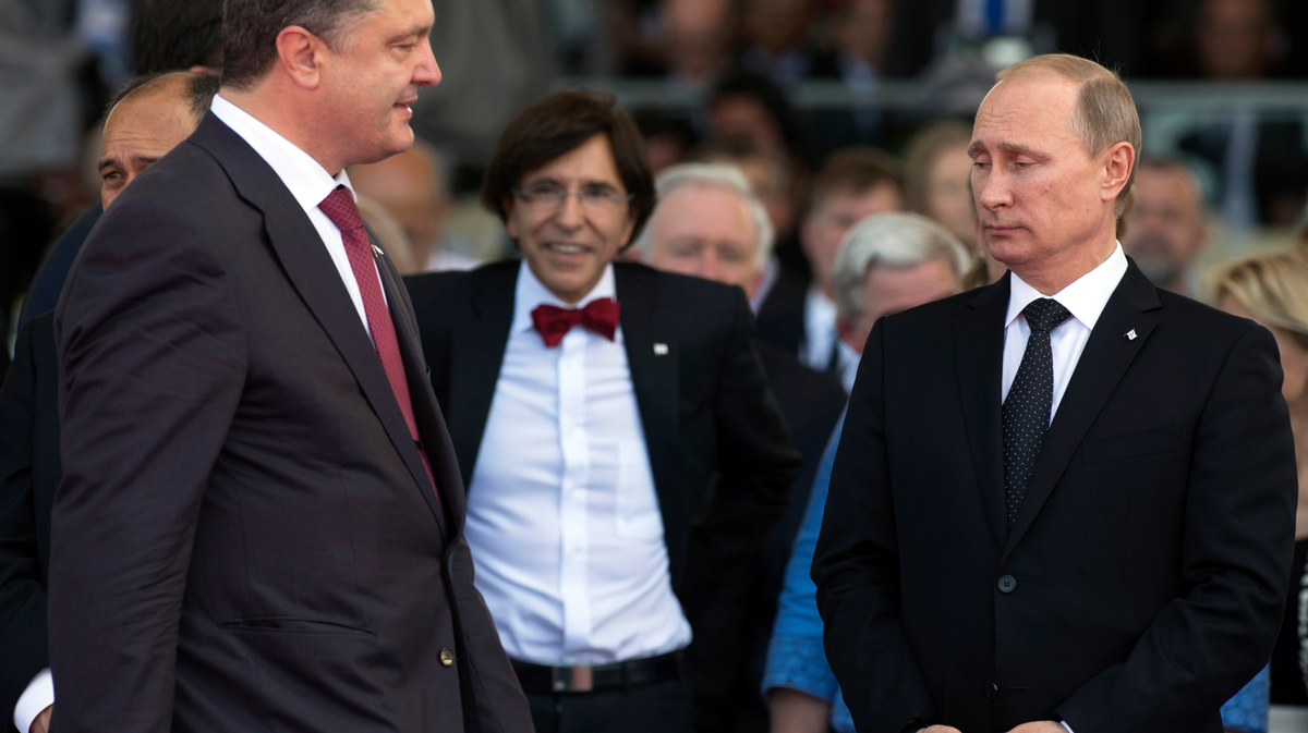 ARCHIVO - El entonces presidente de Ucrania, Petro Poroshenko, a la izquierda, pasa junto al presidente de Rusia, Vladimir Putin, a la derecha, en la conmemoración del 70mo aniversario del Día D Ouistreham, en el oeste de Francia, el 6 de junio de 2014. (AP Foto/Alexander Zemlianichenko, archivo)