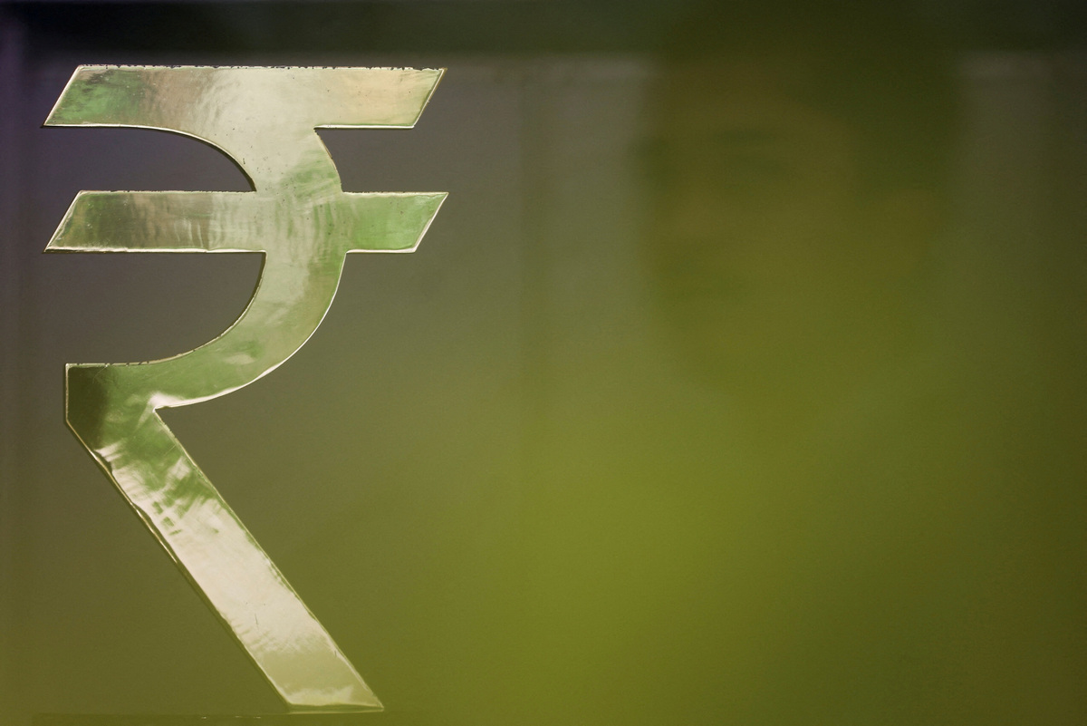FILE PHOTO: A man walks past a Rupee installation at the Reserve Bank Of India (RBI) headquarters in Mumbai, India, April 8, 2026. REUTERS/Francis Mascarenhas/File Photo