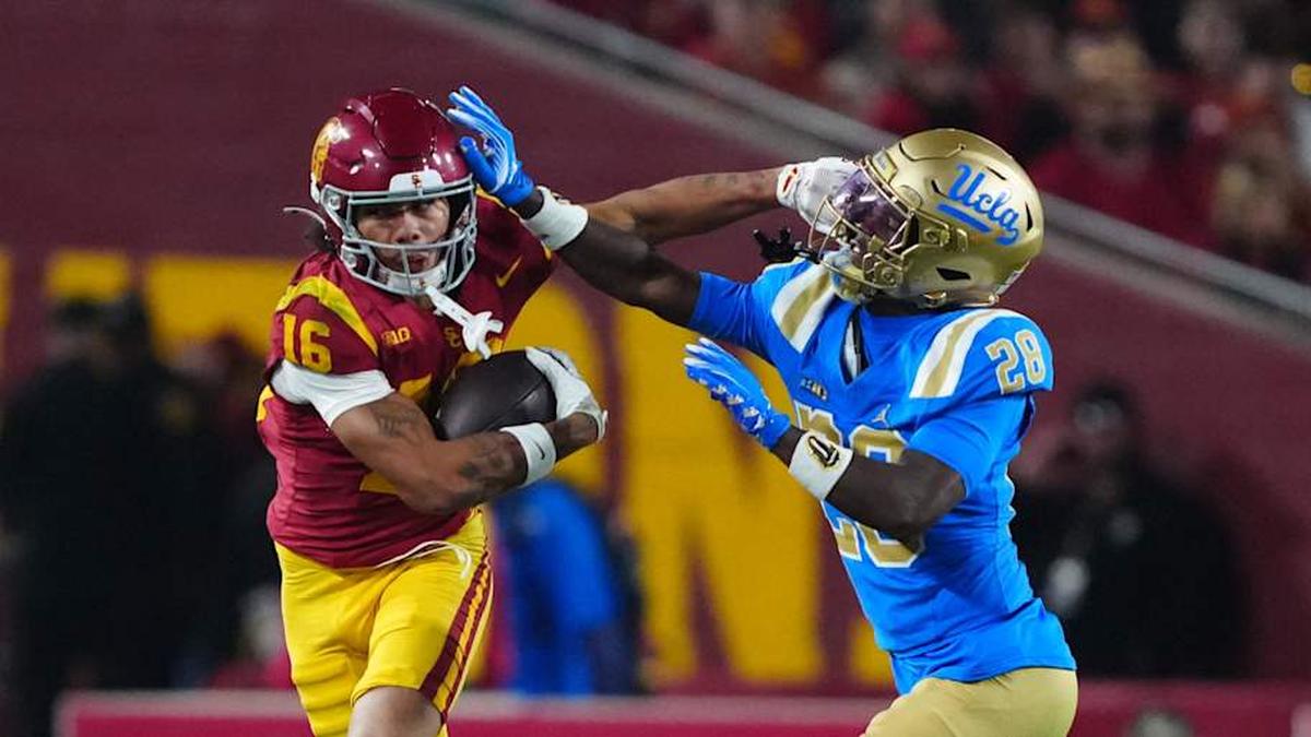  Nov 29, 2025; Los Angeles, California, USA; Southern California Trojans wide receiver Tanook Hines (16) carries the ball against UCLA Bruins defensive back Scooter Jackson (28) in the first half at United Airlines Field at Los Angeles Memorial Coliseum. | Kirby Lee-Imagn Images 