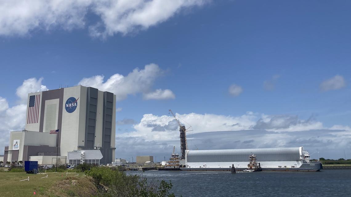 NASA's Pegasus barge arrives to the Kennedy Space Center on Monday, April 27, 2026. Within the barge is the majority of the Space Launch System rocket core stage that will be used on the Artemis III mission slated to fly in mid 2027. NASA will move the core stage into the Vehicle Assembly Building, left, to be stacked on top of the mobile launcher. (Richard Tribou/Orlando Sentinel/TNS)