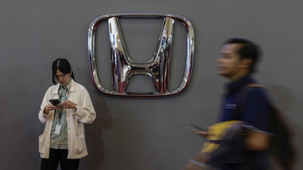 Visitors stand in front of the logo of Japanese automotive manufacturer Honda during the Gaikindo Jakarta Auto Week in Tangerang, Indonesia. Photo by MAST IRHAM / EPA