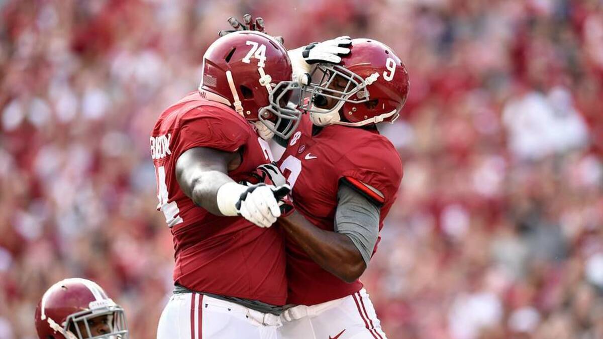 Sep 13, 2014; Tuscaloosa, AL, USA;  Alabama Crimson Tide offensive linesman Cam Robinson (74) leaps up to celebrate wide receiver Amari Cooper (9) touchdown against the Southern Miss Golden Eagles during the first quarter at Bryant-Denny Stadium. Mandatory Credit: John David Mercer-USA TODAY Sports.