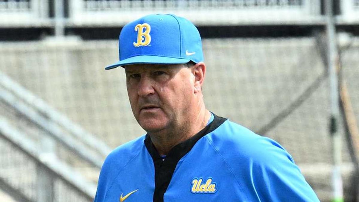  Jun 17, 2025; Omaha, Neb, USA; UCLA Bruins head coach John Savage (22) walks to the dugout before the restart of the game against the LSU Tigers at Charles Schwab Field. Mandatory Credit: Steven Branscombe-Imagn Images | Steven Branscombe-Imagn Images 