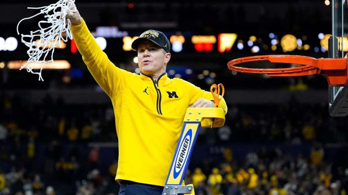 Michigan head coach Dusty May swings the net after winning the NCAA national championship against Connecticut at Lucas Oil Stadium in Indianapolis on April 6. May has been named head coach of the Dallas Mavericks.