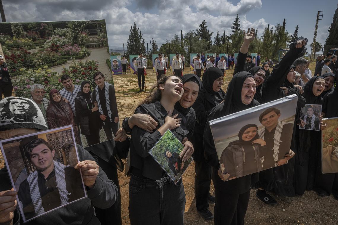 Family members grieve as a convoy of ambulances carrying the coffins of their loved ones arrive in the southern Lebanese village of Bazourieh for a mass funeral, on Monday, April 20, 2026. Families gathered for the funeral of nine people -- both Hezbollah fighters and civilians -- who were killed in recent weeks (David Guttenfelder/The New York Times)