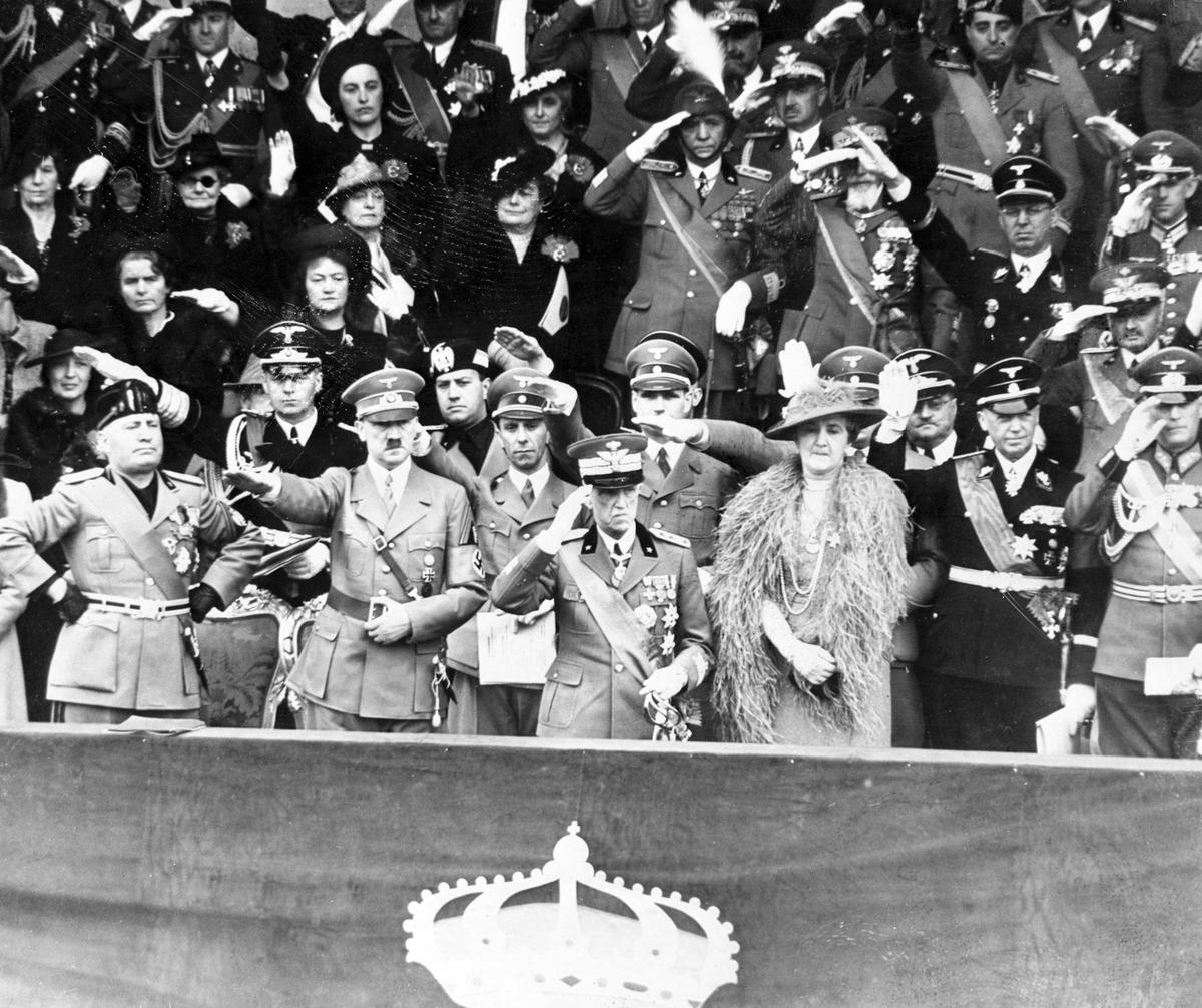  Benito Mussolini, Adolf Hitler, King Victor Emmanuel III and Queen Elena watch a parade held in Hitler's honor in 1938. Behind them, from left: Joachim von Ribbentrop, Galeazzo Ciano, Joseph Goebbels and Rudolf Hess. Bettmann/Getty Images 