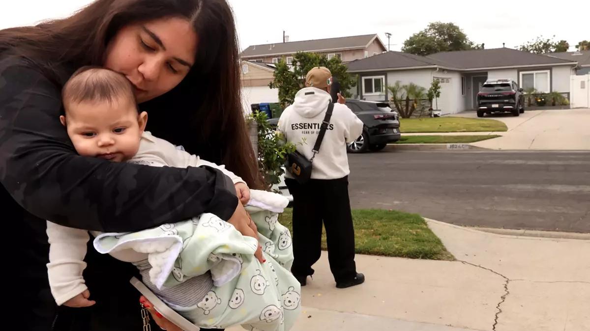 "It's so depressing," said North Hills neighbor Karen Banuelos, holding her 3-month-old son, Alexander. "So devastating for everyone. Postpartum is real." Los Angeles police homicide detectives believe the slaying of a family of four, including a baby, in the quiet Los Angeles neighborhood was the result of a murder-suicide. (Genaro Molina/Los Angeles Times/TNS)
