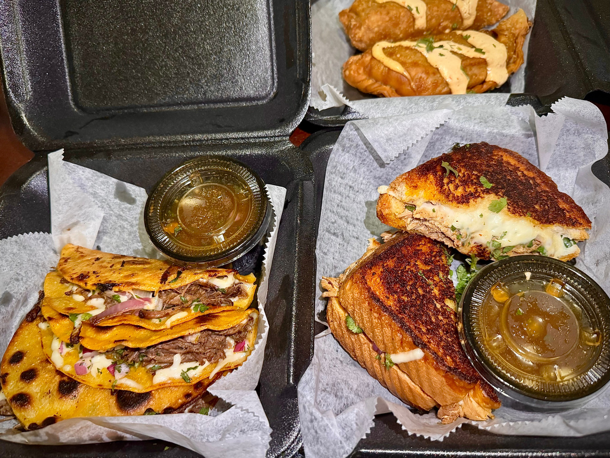 Birria tacos (left), birria grilled cheese and Spanish chicken empanadas from Double Dippin food trailer.