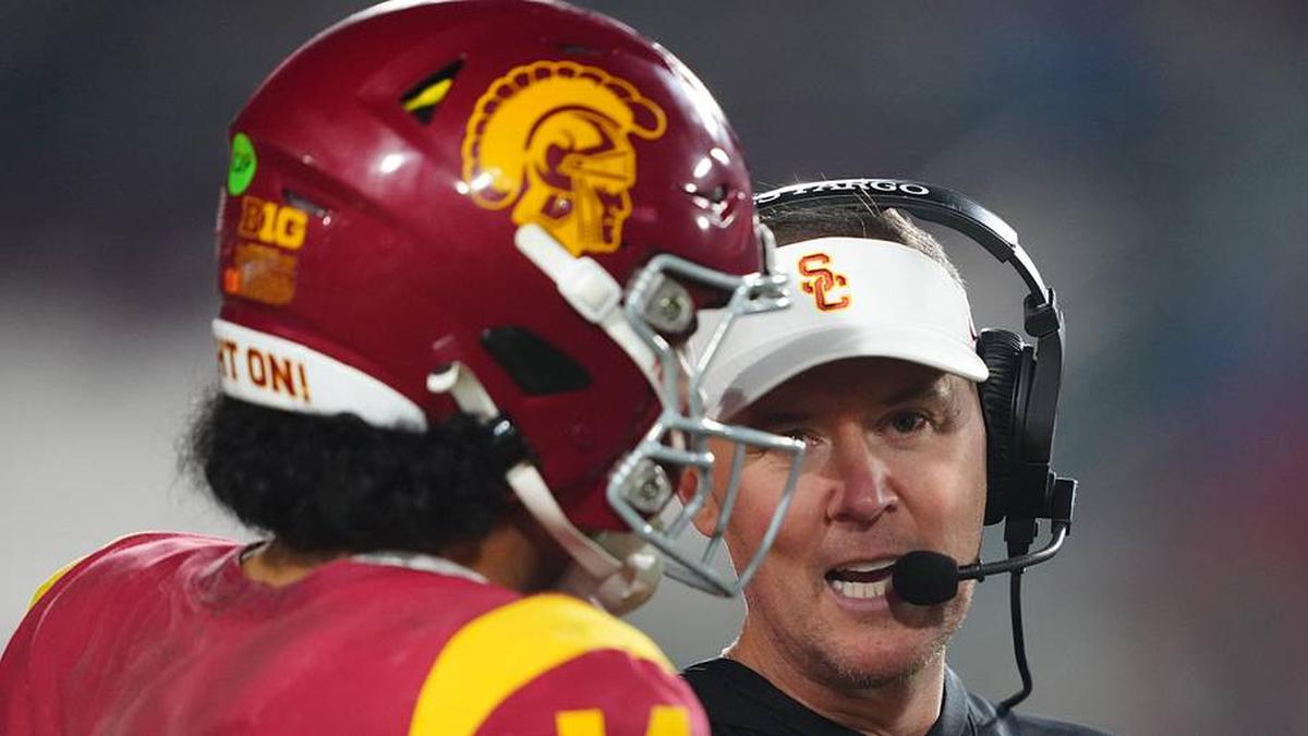  Nov 29, 2025; Los Angeles, California, USA; Southern California Trojans head coach Lincoln Riley (right) talks with quarterback Jayden Maiava (14) in the second half against the UCLA Bruins at United Airlines Field at Los Angeles Memorial Coliseum. Mandatory Credit: Kirby Lee-Imagn Images | Kirby Lee-Imagn Images 