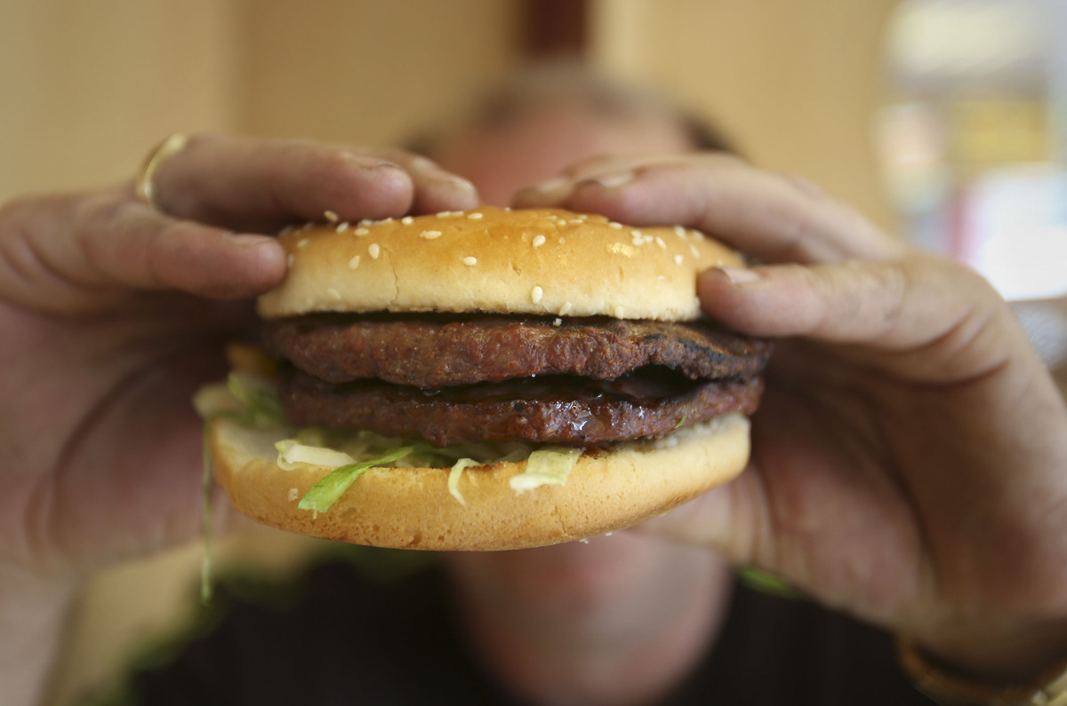  Stock image of a person eating a hamburger. 