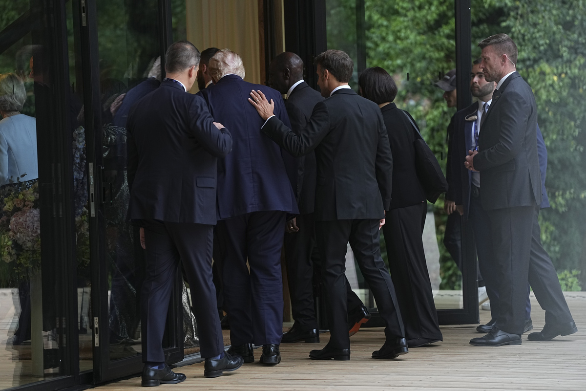 President Emmanuel Macron of France places his hand on the back of President Donald Trump as they attend a cultural performance at the G7 Summit in Evian-les-Bains, France, June 16, 2026. (Haiyun Jiang/The New York Times)