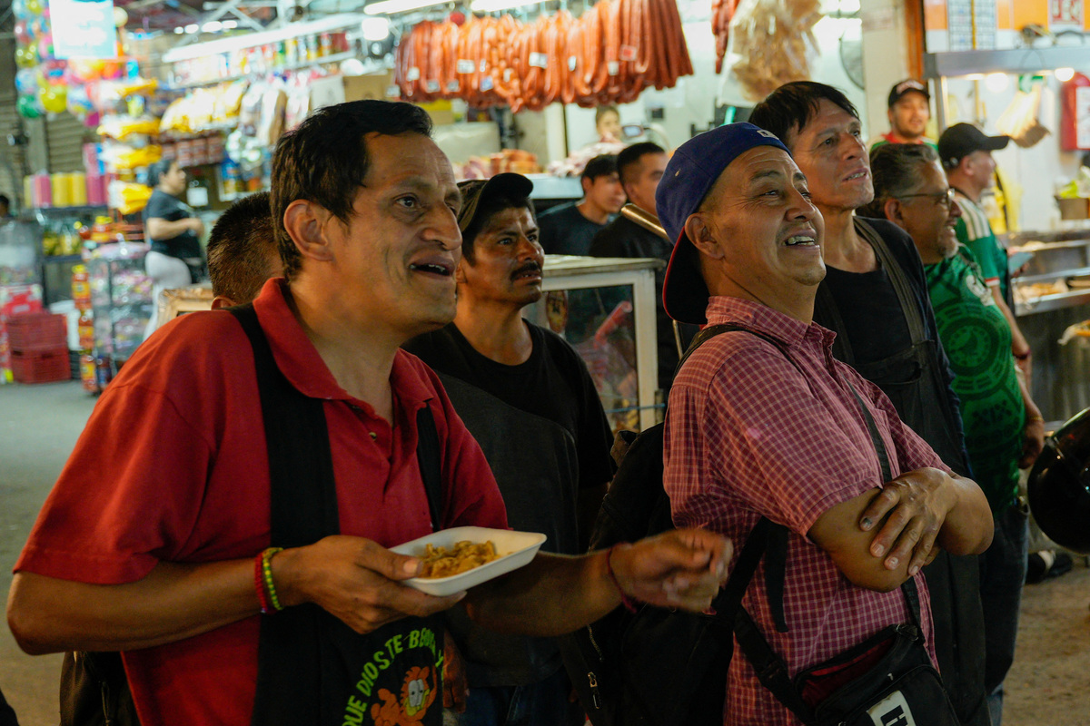 Workers watch the opening match of the 2026 FIFA World Cup on a TV in the Central de Abastos wholesale market, as many Mexicans say they feel excluded despite the tournament's return to the country, citing high ticket prices, paid television access and strict commercial restrictions, in Mexico City, Mexico, June 11, 2026. REUTERS/Armando Vega
