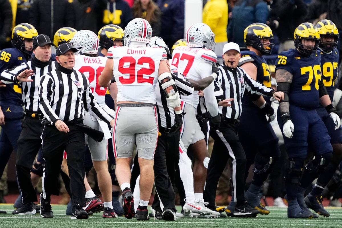  Officials separate Michigan Wolverines and Ohio State Buckeyes players during the NCAA football game at Michigan Stadium in Ann Arbor, Mich. on Nov. 29, 2025. 