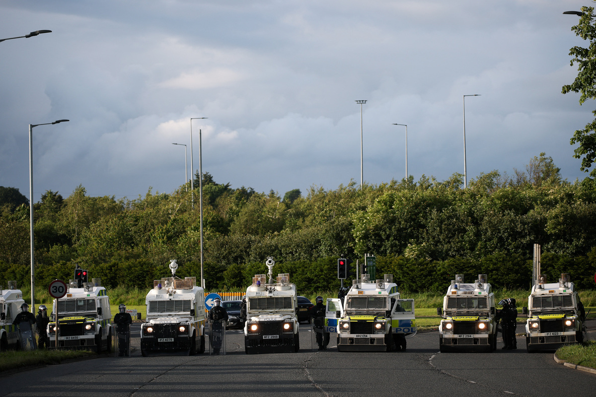 Police and their vehicles block a road to stop anti-immigrant protesters from reaching Sandyknowes Roundabout, following a knife attack on June 8, which left a man seriously injured and prompted police to declare a critical incident, in Belfast, Northern Ireland, June 10, 2026. REUTERS/Isabel Infantes