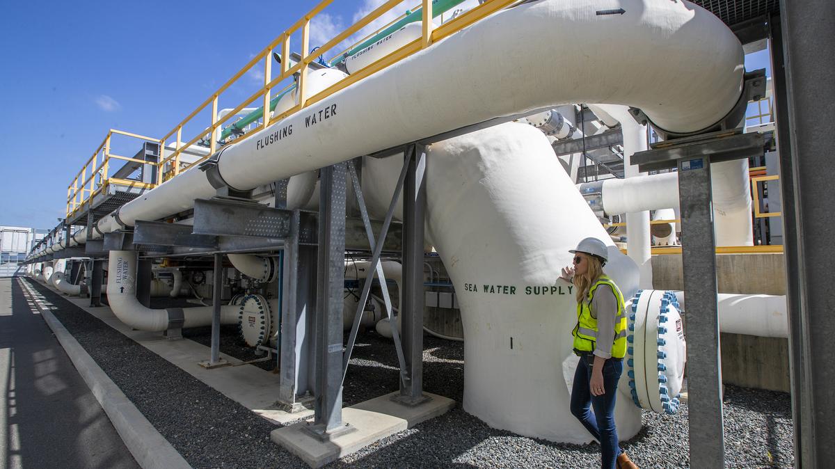 Michelle Peters of Poseidon Water stands by water pipes at the Claude “Bud” Lewis Carlsbad Desalination Plant in Carlsbad, California, in 2022. (Allen J. Schaben/Los Angeles Times/TNS)
