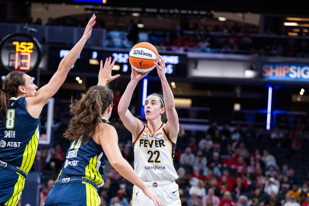  Apr 30, 2026; Indianapolis, IN, USA; Indiana Fever guard Caitlin Clark (22) shoots the ball while Dallas Wings forward Maddy Siegrist (20) and forward Alanna Smith (8) defend in the second half at the Gainbridge Fieldhouse. Mandatory Credit: Trevor Ruszkowski-Imagn Images 