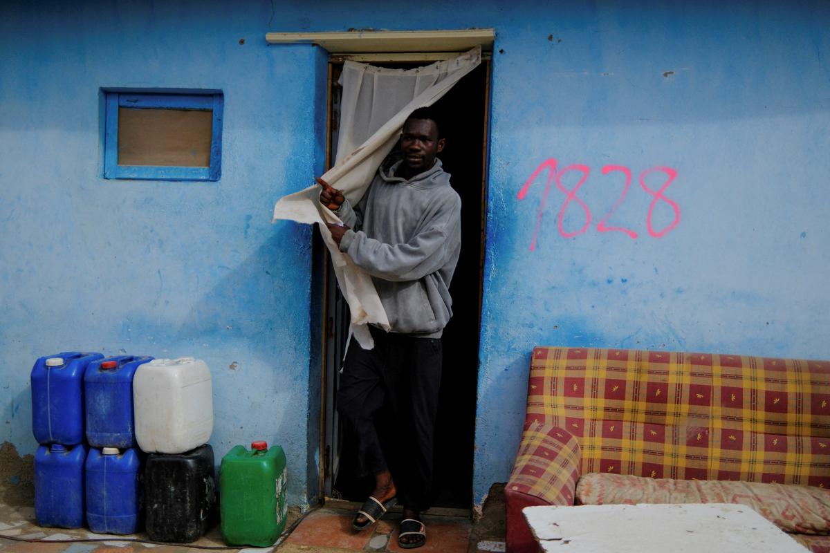 An undocumented migrant from Ghana leaves a friend's shack in a shanty town near plastic-covered greenhouses in Almeria province, home to Europe's largest concentration of agricultural greenhouses, in Nijar, Spain, April 24, 2026. Undocumented migrants there live without reliable electricity and with limited access to water. REUTERS/Nacho Doce