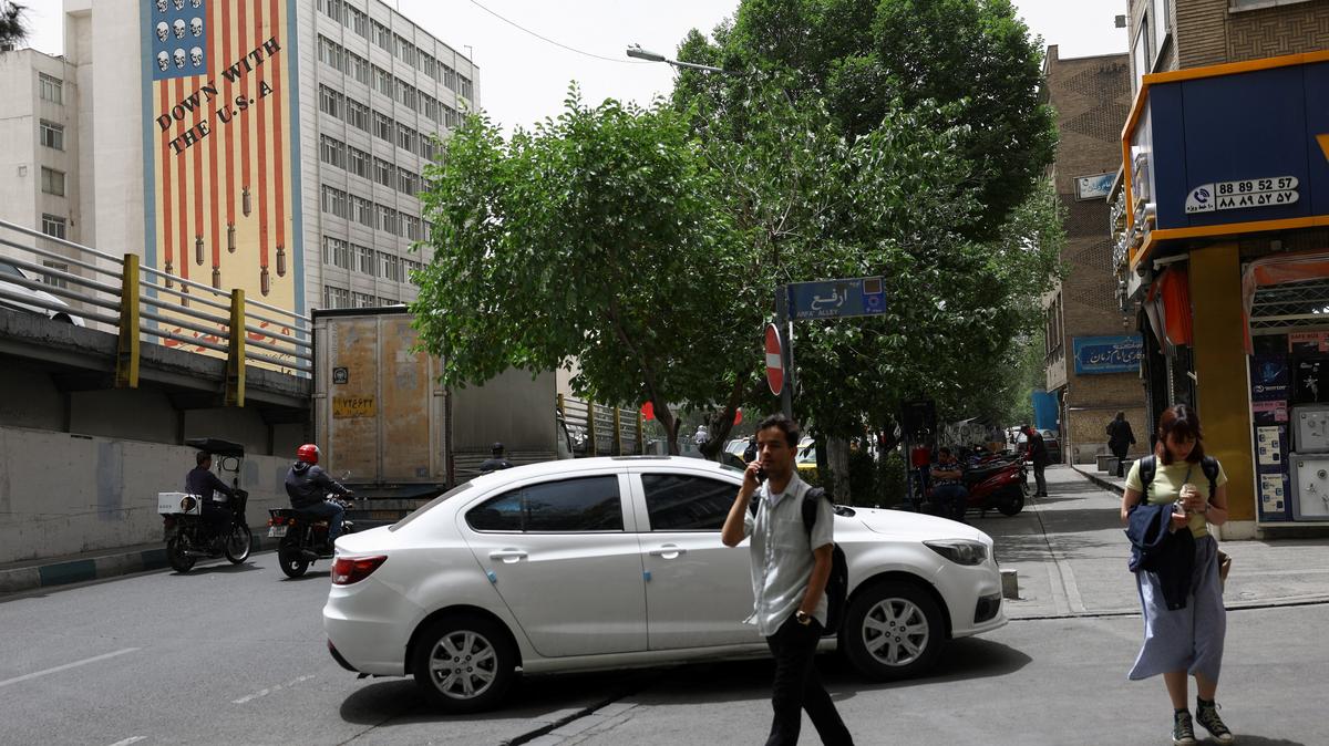People walk near an anti-U.S. mural on a building in Tehran, Iran, May 19, 2026. Majid Asgaripour/WANA (West Asia News Agency) via REUTERS
