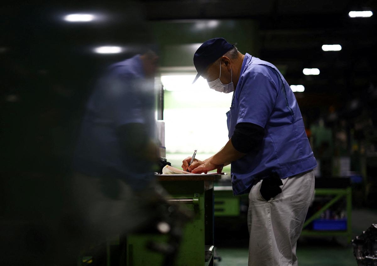 FILE PHOTO: A worker writes next to a precision-machining machine for automotive parts inside a factory at Kyowa Industrial Co. in Takasaki, Gunma Prefecture, Japan April 11, 2025.  REUTERS/Issei Kato/File Photo