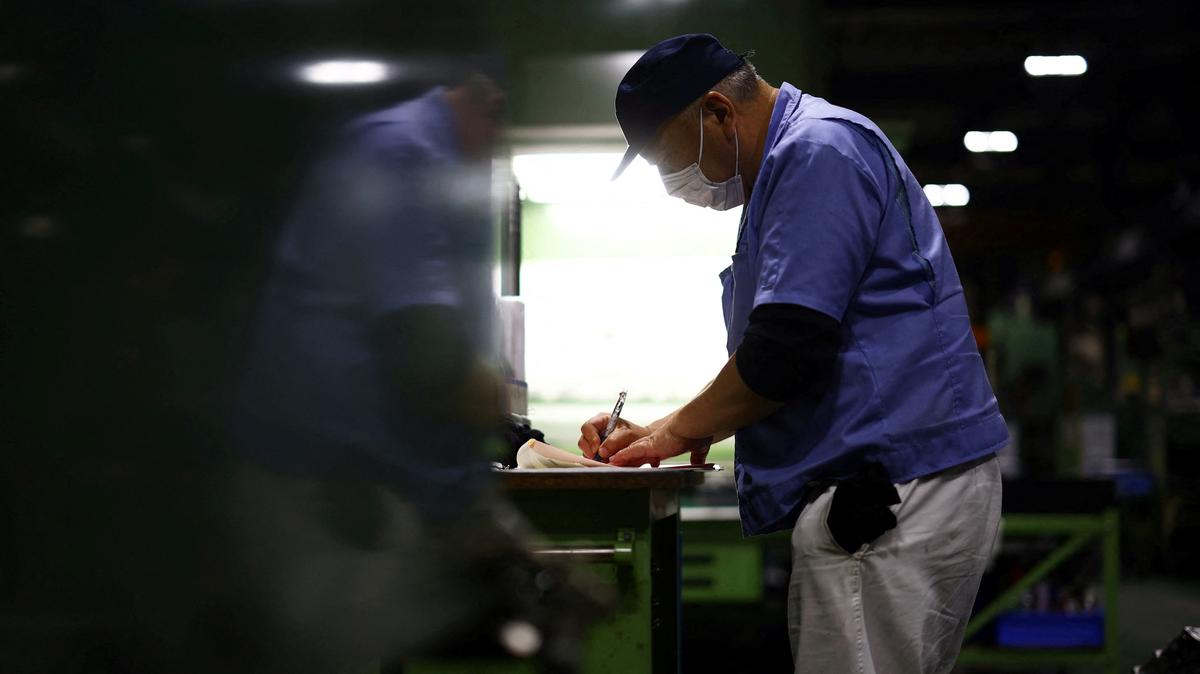 FILE PHOTO: A worker writes next to a precision-machining machine for automotive parts inside a factory at Kyowa Industrial Co. in Takasaki, Gunma Prefecture, Japan April 11, 2025.  REUTERS/Issei Kato/File Photo