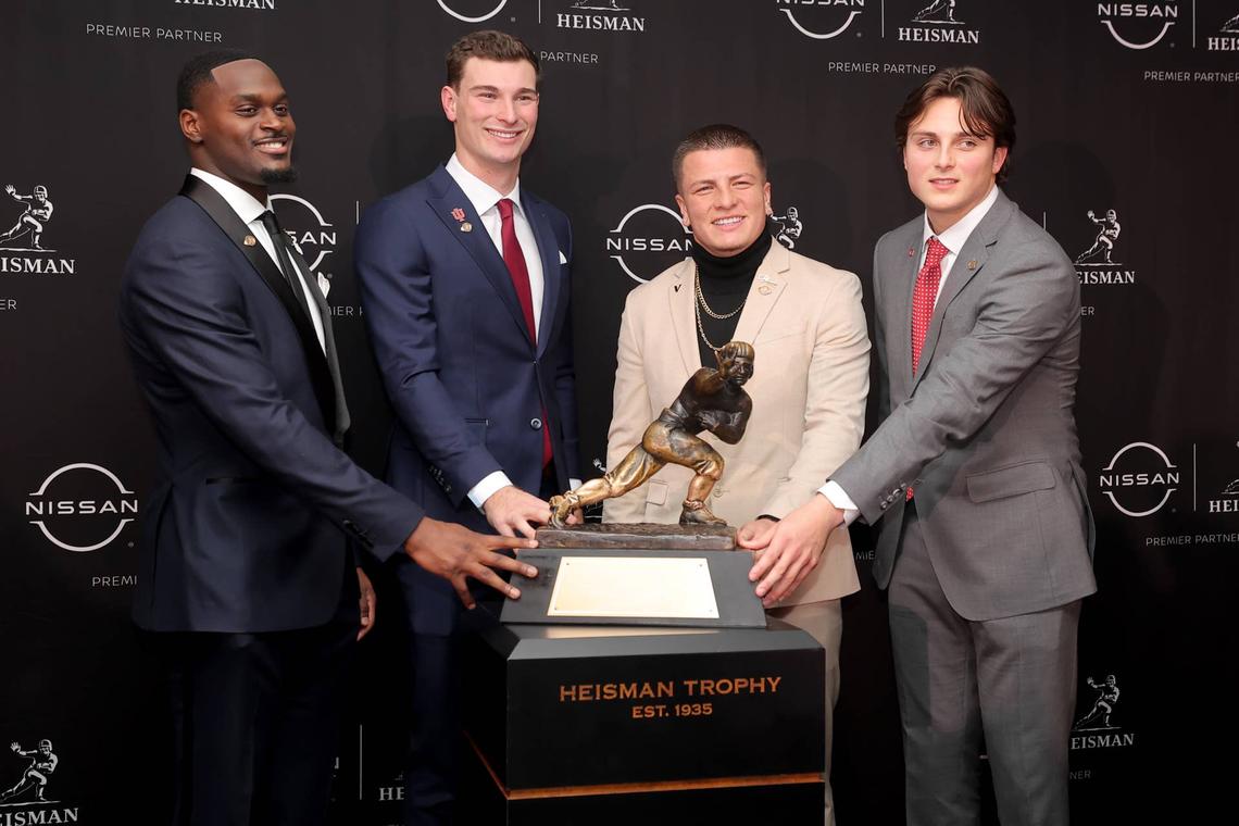  (left to right) Heisman finalists Jeremiyah Love, Fernando Mendoza, Diego Pavia and Julian Sayin pose with the Heisman trophy. Brad Penner-Imagn Images
