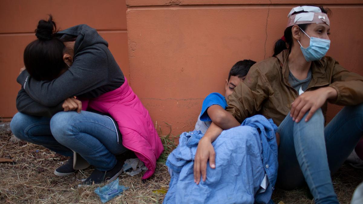 En esta imagen del 17 de enero de 2021, mujeres de una caravana de migrantes hondureños que resultaron heridas cuando intentaban llegar a la frontera estadounidense lloran junto a una autopista tras chocar con policías y soldados guatemaltecos en Vado Hondo, Guatemala. (AP Foto/Sandra Sebastian, Archivo)