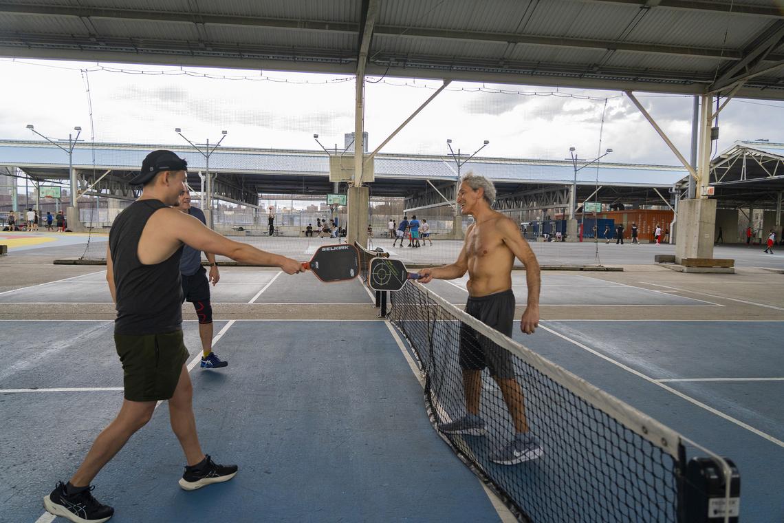 People play pickleball at Pier 2 in the Brooklyn borough on April 1, 2026. Tennis vs. Pickleball: both are great ways to get out and get moving, and both can cause injuries. But there are a few important differences. (Calla Kessler/The New York Times)