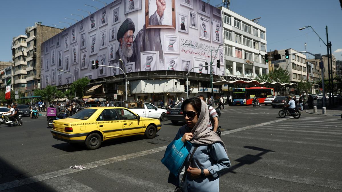A woman walks near a billboard featuring an image of the late Supreme Leader of Iran, Ayatollah Ali Khamenei, in Tehran, Iran, May 11, 2026. Majid Asgaripour/WANA (West Asia News Agency) via REUTERS