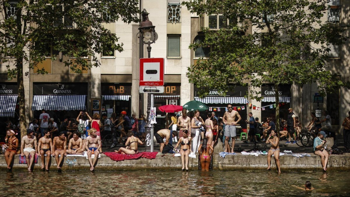 People cool off along the Canal Saint-Martin in Paris on Saturday. Photo by Yoan Valat/EPA