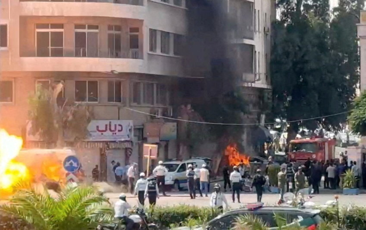 Emergency personnel work as smoke and fire rise at the site where explosive devices blew up near a hotel where French President Emmanuel Macron was meant to be staying, in Damascus, Syria, in this screengrab obtained from a video, July 7, 2026. REUTERS/Yamam Al Shaar