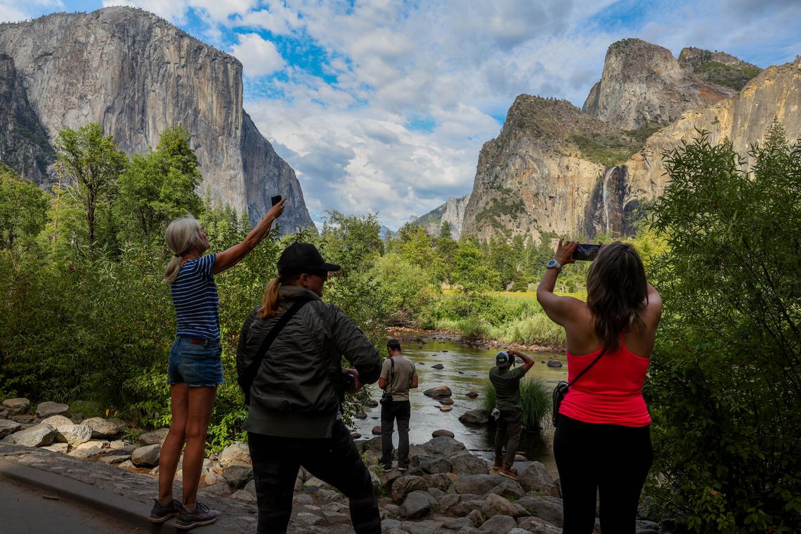 Visitors contemplate and take photos of El Capitan, left, and Yosemite Valley in Yosemite, Calif., on Thursday, July 24, 2025. 
