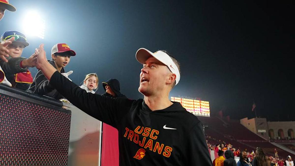  Nov 29, 2025; Los Angeles, California, USA; Southern California Trojans head coach Lincoln Riley celebrates with fans after the game against the UCLA Bruins at United Airlines Field at Los Angeles Memorial Coliseum. Mandatory Credit: Kirby Lee-Imagn Images | Kirby Lee-Imagn Images 