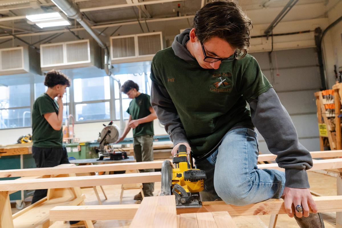  Jeff Flagg, 17, cuts wood for a house he is building with his carpentry classmates at Harvard H. Ellis Technical School in Danielson, CT on April 7, 2026. Credit: Sophie Park for The Hechinger Report