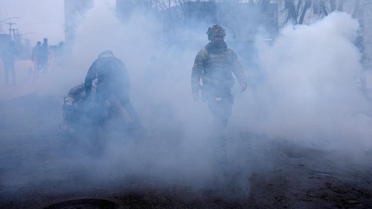 FILE PHOTO: A federal agent walks as others hold a person down while being surrounded by tear gas used to deter protesters, as immigration enforcement continues after a U.S. Immigration and Customs Enforcement (ICE) agent fatally shot Renee Nicole Good on January 7 during an immigration raid, in Minneapolis, Minnesota, U.S., January 21, 2026. REUTERS/Leah Millis/File Photo