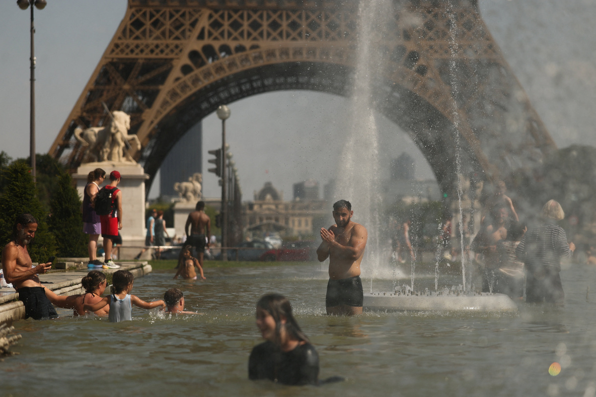 People cool off in the Trocadero Fountain near to the Eiffel Tower as temperatures rise during a heatwave affecting a large part of the country, in Paris, France, June 24, 2026. REUTERS/Gonzalo Fuentes