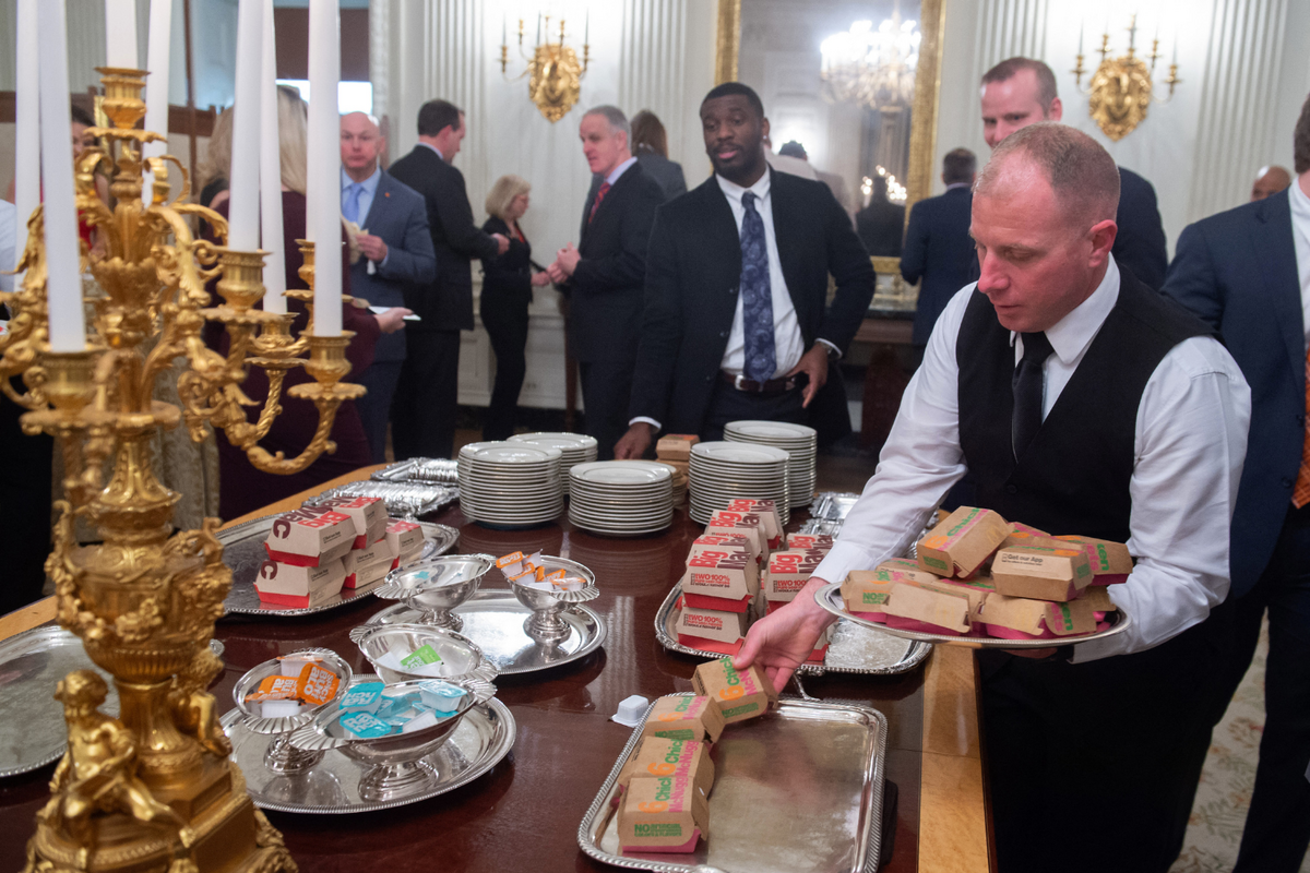  White House ushers plate chicken nuggets from McDonalds, some of the fast food the president purchased for a ceremony honoring the 2018 College Football Playoff National Champion Clemson Tigers in the State Dining Room of the White House in Washington, D.C., January 14, 2019. 