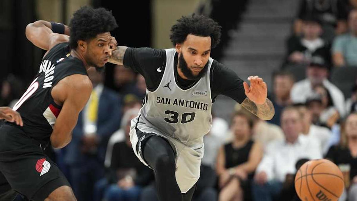  Apr 8, 2026; San Antonio, Texas, USA; San Antonio Spurs forward Julian Champagnie (30) and Portland Trail Blazers guard Scoot Henderson (00) battle for a loose ball during the second half at Frost Bank Center. | Scott Wachter-Imagn Images 
