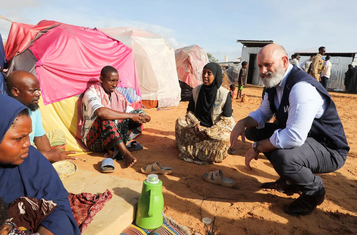 The World Food Programme’s Assistant Executive Director for Programme Operations, Matthew Hollingworth, talks to civilians during his visit to a camp for the internally displaced people to assess the knock on effects from the escalation in the Middle East, alongside drought and sharp cuts in humanitarian funding that are worsening hunger, in Kahda district of Mogadishu, Somalia May 7, 2026. REUTERS/Feisal Omar