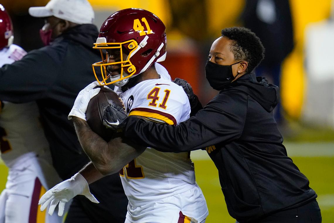Jennifer King, right, works with Washington Football Team running back J.D. McKissic (41) before the team’s NFL wild-card playoff football game against the Tampa Bay Buccaneers, Saturday, Jan. 9. On Jan. 26, she was named Washington’s assistant running backs coach.  She’s the first Black female assistant position coach in NFL history.