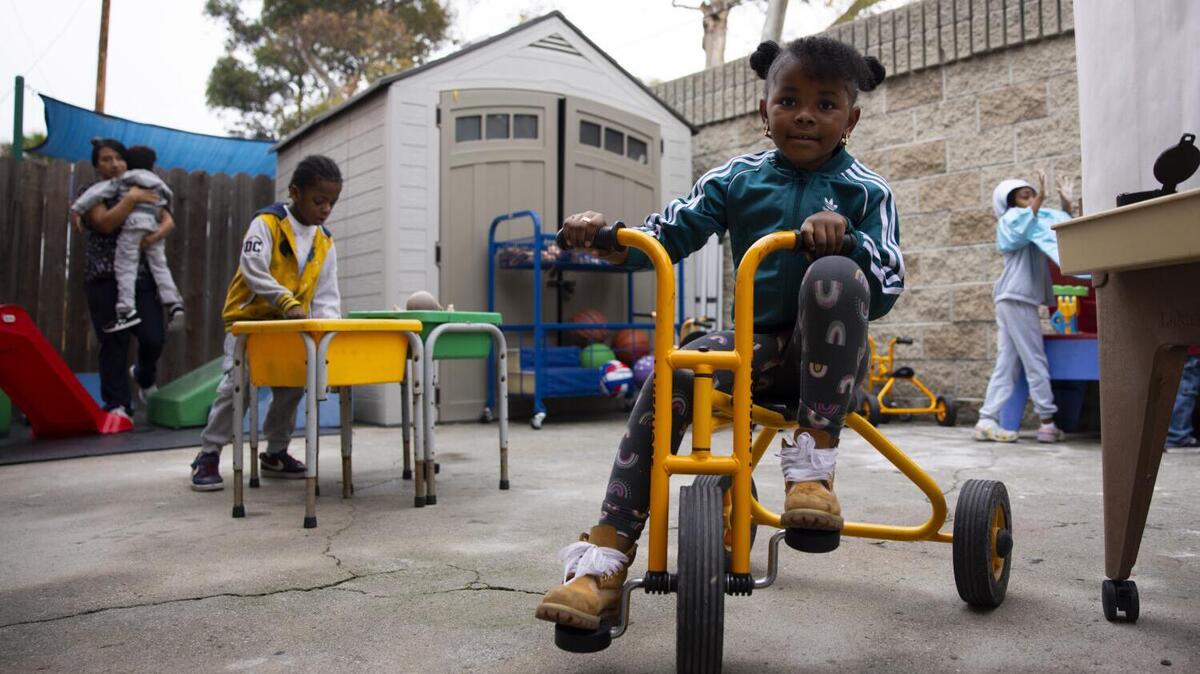 Children and staff play outside at a child care family home service, "Touched By an Angel Child Care"