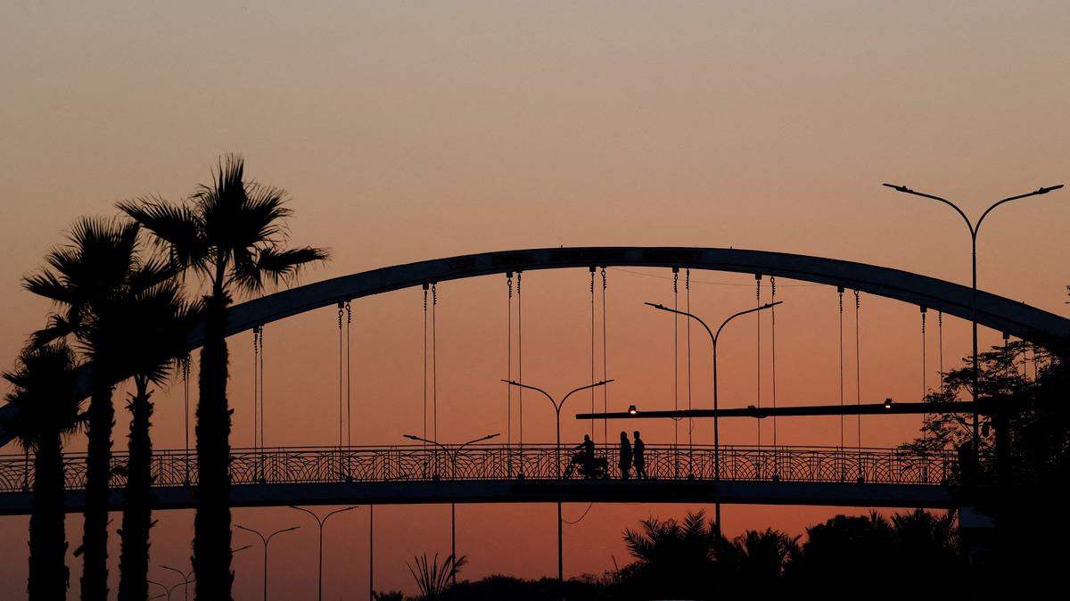 FILE PHOTO: People are silhouetted as they cross a pedestrian bridge during sunset hours, in Islamabad, Pakistan, November 12, 2025. REUTERS/Akhtar Soomro/File Photo