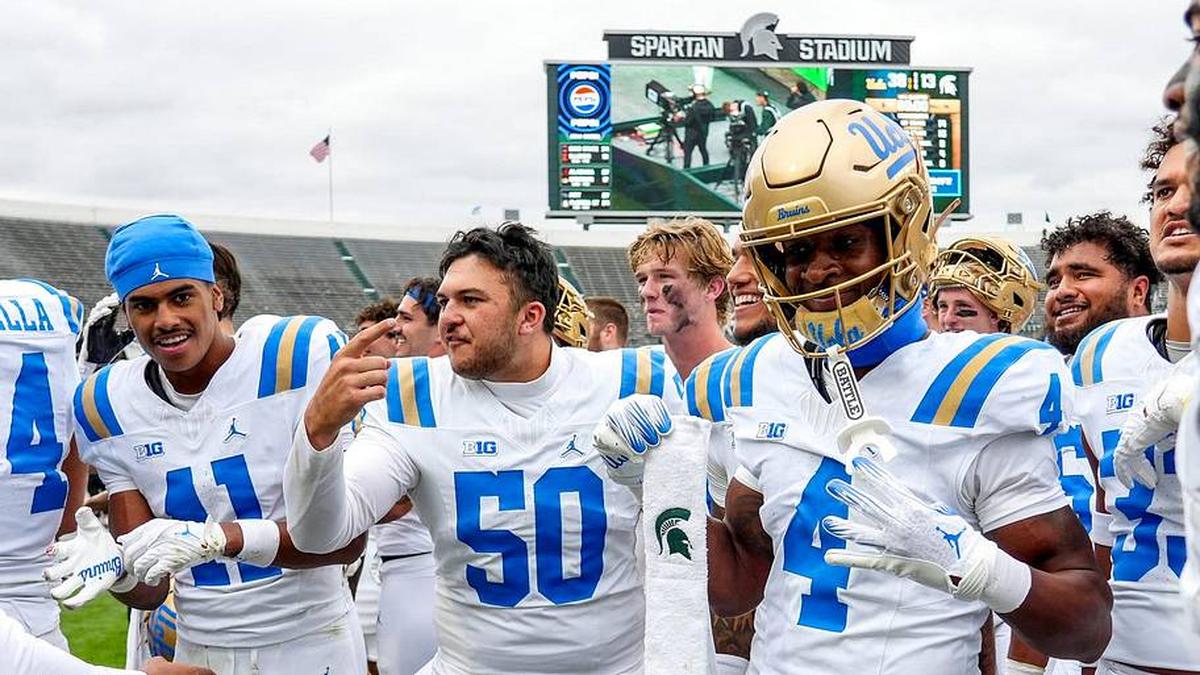  UCLA's Ezavier Staples, center, holds up a Michigan State towel while celebrating with the team after the Bruins win over Michigan State on Saturday, Oct. 11, 2025, at Spartan Stadium in East Lansing. | Nick King/Lansing State Journal / USA TODAY NETWORK via Imagn Images 